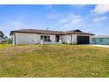 Charming single-story home featuring a dark brown roof and garage door with a well-maintained lawn at 3315 Elkcam Blvd, Port Charlotte, FL 33952