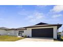 A bright single-story home with a dark brown roof, white exterior, and attached garage at 3315 Elkcam Blvd, Port Charlotte, FL 33952