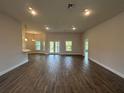 Spacious living room features hardwood floors and abundant natural light from large windows and glass doors at 411 Paramaribo St, Punta Gorda, FL 33983
