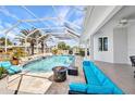 Screened-in pool with spa and sun shelf, surrounded by travertine and outdoor seating at 4213 Gardner Dr, Port Charlotte, FL 33952