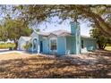 Side view of light blue home, featuring a well-maintained lawn and a chimney at 6308 Grove Blvd, Punta Gorda, FL 33982