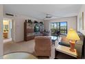 Living room features neutral walls, ceiling fan, and large sliding glass doors to a screened lanai at 72 Boundary Blvd # 226, Rotonda West, FL 33947