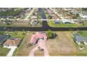 Expansive aerial view of the home, showcasing a red tiled roof, large lot, and access to a canal at 730 Boundary Blvd, Rotonda West, FL 33947