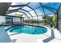 Screened in pool boasts clear water with seating and views of a canal at 12420 Minot Ave, Port Charlotte, FL 33981