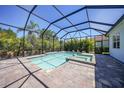 Screened-in swimming pool and hot tub surrounded by lush tropical landscaping at 12472 Davie Ct, Venice, FL 34293