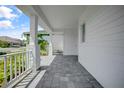 Side view of a porch showing pavers and white pillars and railing at 12472 Davie Ct, Venice, FL 34293