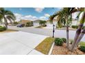 Quiet street view showcasing well-maintained homes with manicured lawns and palm trees at 1677 Palace Ct, Punta Gorda, FL 33980