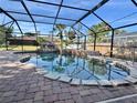 Beautiful screened pool with a unique rock waterfall and spa for relaxation at 18459 Inwood Ave, Port Charlotte, FL 33948