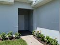Welcoming entryway with stone path, lush landscaping, and neutral paint at 198 Arch Dr, Rotonda West, FL 33947