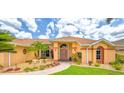 Inviting home entrance with colorful plants, stone bench, and double doors at 2202 Peterborough Rd, Punta Gorda, FL 33983