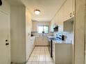 Well-lit kitchen with white cabinets, tiled countertops, and essential appliances for culinary enthusiasts at 2314 Lee Ter, Port Charlotte, FL 33952