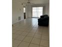 Bright living room with tiled floors, a ceiling fan and a sliding door to the balcony at 25050 Sandhill Blvd # B3, Punta Gorda, FL 33983