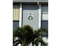 The Pines condo sign with a palm tree in the foreground on a sunny day at 25050 Sandhill Blvd # B3, Punta Gorda, FL 33983