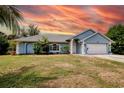 Charming single-story home featuring a manicured lawn and a two-car garage at 2685 Nanette Ln, North Port, FL 34286