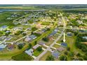 An aerial view of a neighborhood with houses, green spaces, and a river in the distance at 27263 Deep Creek Blvd, Punta Gorda, FL 33983