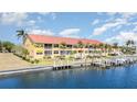 Exterior water view of the condo from the side with canal, dock, and landscaping at 3228 Purple Martin Dr # 116, Punta Gorda, FL 33950