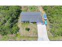 Aerial view of home displaying its roof, lawn, driveway with boat, and proximity to surrounding trees at 4229 Cockrell St, Port Charlotte, FL 33948