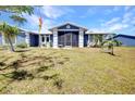 Well-maintained home with a screened-in entryway, a metal roof, and lush landscaping enhancing curb appeal at 4474 Ozark Ave, North Port, FL 34287
