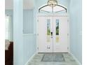 Bright entryway features double doors, modern light fixture, and light wood-look flooring at 4569 Kenvil Dr, North Port, FL 34288