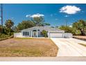 Charming one-story home with a two-car garage, light blue exterior paint, and well-manicured landscaping at 4569 Kenvil Dr, North Port, FL 34288