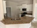 Bright kitchen features white cabinets, granite countertops, and stainless steel appliances at 47 Tee View Rd, Rotonda West, FL 33947