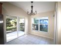 Bright dining area with sliding glass doors to the screened lanai and a modern chandelier at 4749 Oakley Rd, North Port, FL 34288