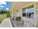 Welcoming front porch with white rocking chairs, plants, and a decorative flamingo at 6235 Bixel Ln, Englewood, FL 34224