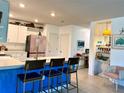 Bright kitchen featuring a blue center island with bar seating and stylish modern appliances at 7232 W Lenox Cir, Punta Gorda, FL 33950