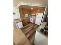 Efficient kitchen featuring wood cabinetry and white appliances at 805 S Green Cir, Venice, FL 34285