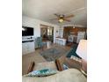 Comfortable living room with a ceiling fan and views into the kitchen and sitting area at 805 S Green Cir, Venice, FL 34285