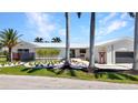 Charming home featuring modern landscaping, a sleek white exterior, and a metal roof at 810 Napoli Ln, Punta Gorda, FL 33950