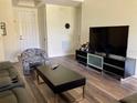 Cozy living room with wood floors, modern furniture and a flat screen television for relaxing entertainment at 98 Vivante Blvd # 9834, Punta Gorda, FL 33950