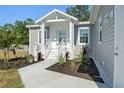 Inviting front porch with stylish landscaping, walkway, and white picket fence at 11136 Grapefruit Ln, Punta Gorda, FL 33955