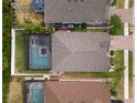 Aerial view of a property with a screened-in pool, neighboring homes, and manicured landscaping at 15193 Mille Fiore Blvd, Port Charlotte, FL 33953