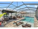 Luxurious screened-in pool area with a covered gazebo, sun loungers, and a built-in hot tub at 15193 Mille Fiore Blvd, Port Charlotte, FL 33953