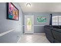 Bright entryway featuring neutral tile flooring, decorative molding, artwork, and a stylish front door at 1773 Portage St, North Port, FL 34287