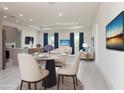 Spacious living room with dining area, recessed lighting, and two large TVs in the home at 1816 Braddock Ave, North Port, FL 34288