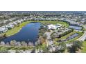 Aerial view of a community with a lake, clubhouse, pool, and tennis courts at 2061 Willow Hammock Cir # 303, Punta Gorda, FL 33983