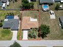 Aerial view of a single-story home showing the roof, driveway and the property's boundaries at 21035 Exmore Ave, Port Charlotte, FL 33952
