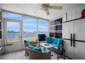 Bright sunroom with lake view, comfortable seating, and tiled flooring at 26290 Rampart Blvd # D, Punta Gorda, FL 33983