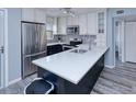 Modern kitchen with stainless steel appliances and a large island with white countertop at 26485 Rampart Blvd # C1, Punta Gorda, FL 33983