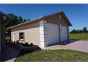 Detached two-car garage with white doors and framed by a well manicured green lawn at 29211 Picador St, Punta Gorda, FL 33982