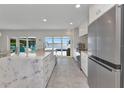 Open concept kitchen features a marble island with stainless steel appliances and water views at 3016 Curry Ter, Port Charlotte, FL 33981