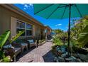 Charming walkway and front sitting area with comfortable wicker chairs, showcasing the lush tropical landscaping and inviting ambiance at 3051 Chicory Ter, Punta Gorda, FL 33983