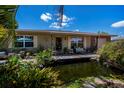 Inviting front of house with pond, dock, and comfortable seating area, enhanced by lush greenery and tasteful decor at 3051 Chicory Ter, Punta Gorda, FL 33983