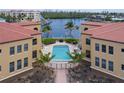 Community pool surrounded by condos, tropical landscaping, and a fence at 3334 Purple Martin Dr # 214, Punta Gorda, FL 33950