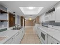 Well-lit kitchen with a skylight, stainless steel sink, and a convenient pass-through to the adjacent living space at 3561 Middletown St, Port Charlotte, FL 33952