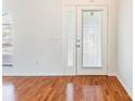 Bright entryway featuring wood floors, a front door with decorative glass, and white walls at 4260 Kessler Ter, North Port, FL 34287