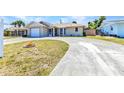 Charming one-story home with a curving driveway, front lawn, and an attached garage at 428 Briarwood Rd, Venice, FL 34293