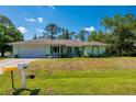 Charming single-story home with a well-manicured lawn, attached garage, and lush landscaping at 4461 La France Ave, North Port, FL 34286